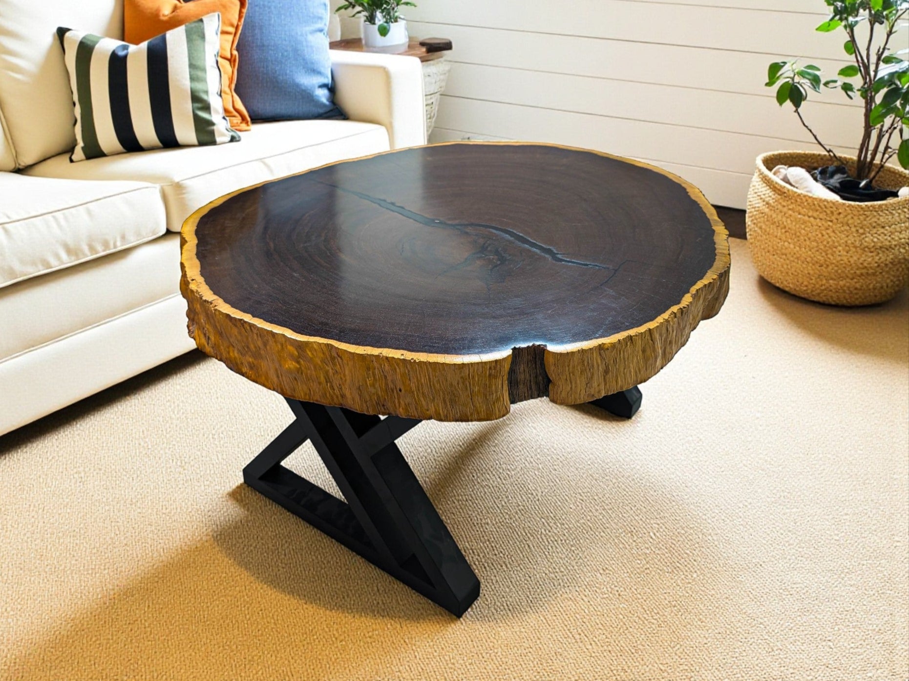 Wooden coffee table in a living room setting with a couch and plants.