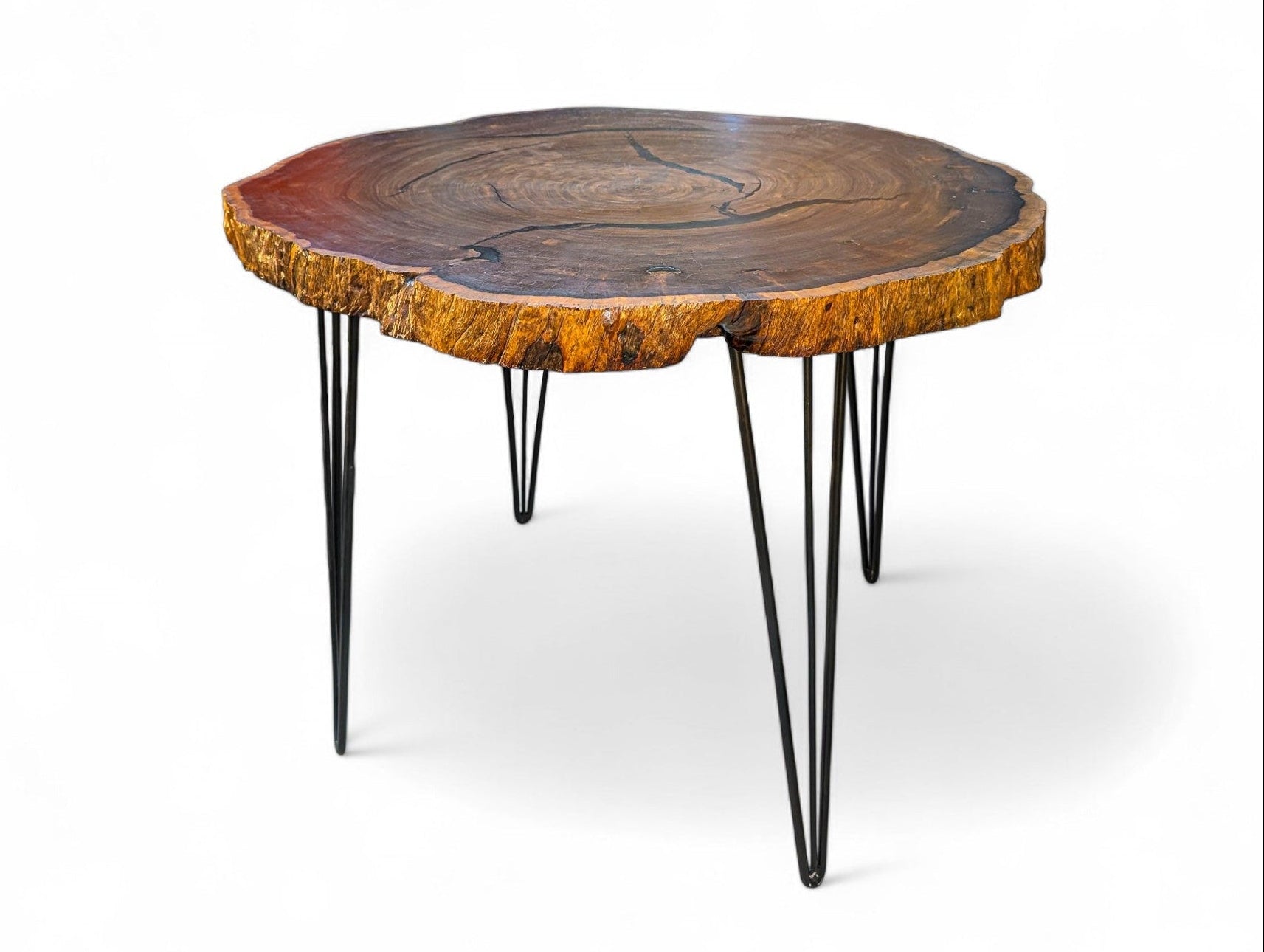 Wooden table with a natural edge and black metal legs on a white background