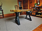 Wooden bench with a textured surface in a room with wooden walls and a rug.