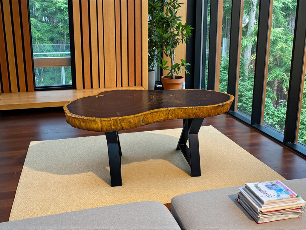 Wooden coffee table in a room with large windows and a plant