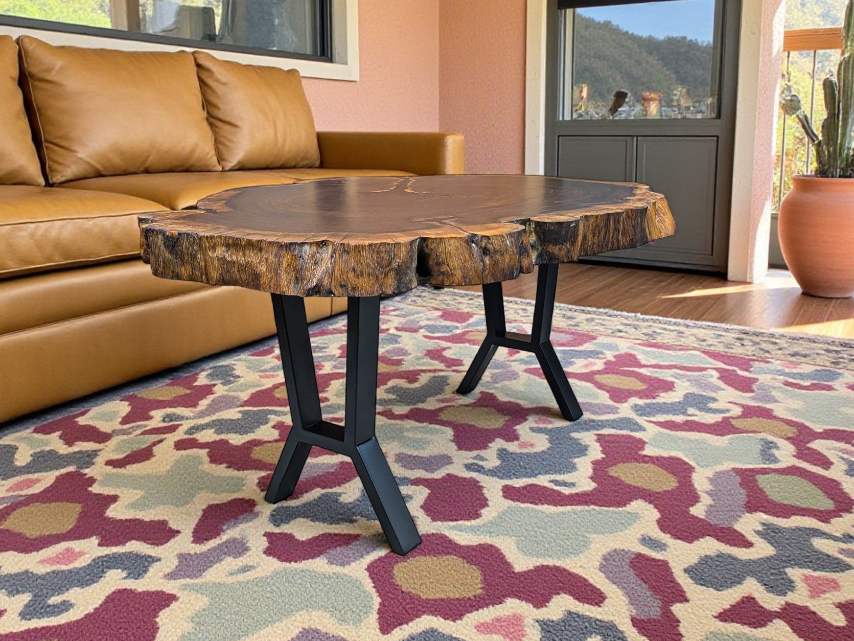 Living room with a brown leather sofa, wooden table, and patterned rug.