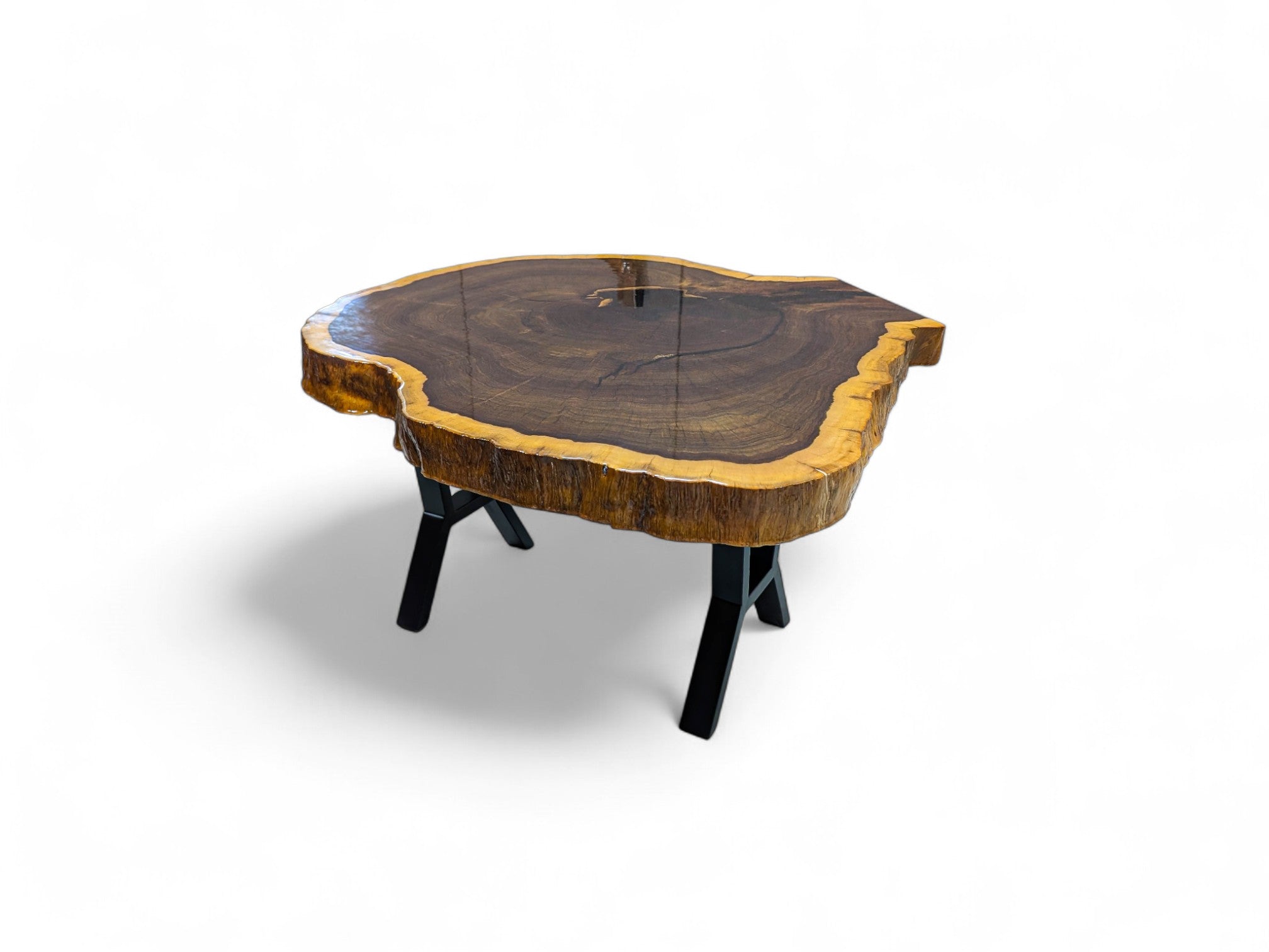 Wooden coffee table with a natural edge design on a white background