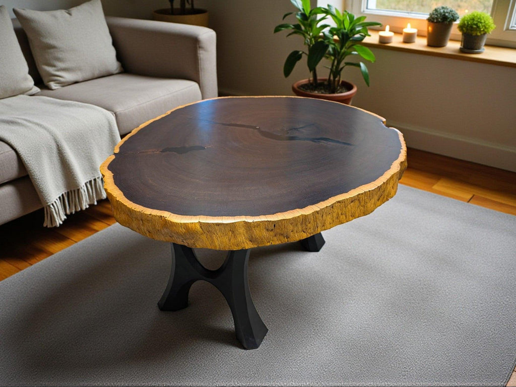 Round wooden coffee table in a living room setting with a sofa and plants.